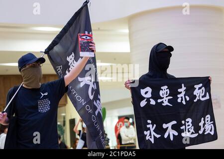 HONGKONG, HONGKONG SAR, CHINA: 15. JUNI 2020. Demonstranten in der Pacific Place Mall in der Admiralität Hongkong winken pro Unabhängigkeit Zeichen und unterschreiben "Ruhm zu Hongkong"; die Protesthymne. Sie sind dort, um des ersten Todes von Demokratiedemonstranten vor einem Jahr zu gedenken. Marco Leung starb am 15. Juni 2019 an Gerüsten vor dem Gebäude. Er wurde bekannt als der Regenmantel Mann. Alamy Stock Image/Jayne Russell Stockfoto