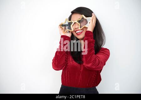 Horizontale Medium Porträt von jungen asiatischen Frau mit Spaß versuchen auf großen sternförmigen Brillen, weißen Hintergrund, kopieren Raum Stockfoto