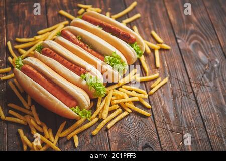 American Hot Dogs sortiert in Reihe. Mit Pommes frites serviert. Stockfoto