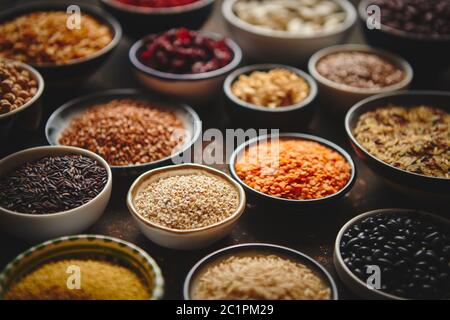 Verschiedene superfoods in kleinen Schüsseln auf dunklen Rusty Hintergrund Stockfoto