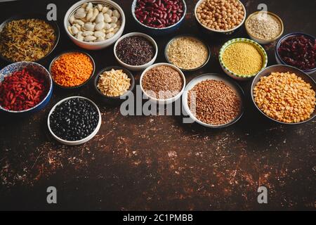 Verschiedene superfoods in kleinen Schüsseln auf dunklen Rusty Hintergrund Stockfoto