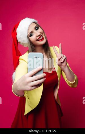 Hübsches Mädchen in rot Santa Hut und Kleid unter selfie über Zelle ov Stockfoto