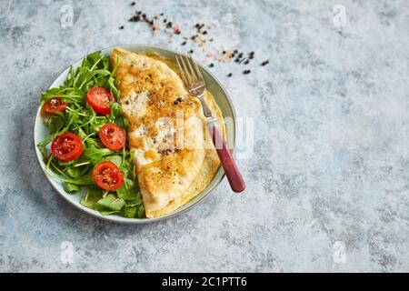 Klassische ei Omelette mit Cherry Tomaten und Rucola Salat auf Seite Stockfoto