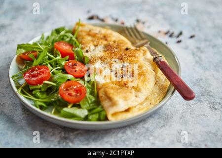 Klassische ei Omelette mit Cherry Tomaten und Rucola Salat auf Seite Stockfoto