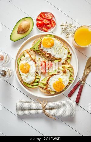 Leckeres und gesundes Frühstück mit in Scheiben geschnittenen avocado Sandwiches mit Spiegelei Stockfoto