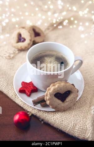 Weihnachten herzförmige Plätzchen- und Kaffeetasse mit roter Dekoration. Stockfoto