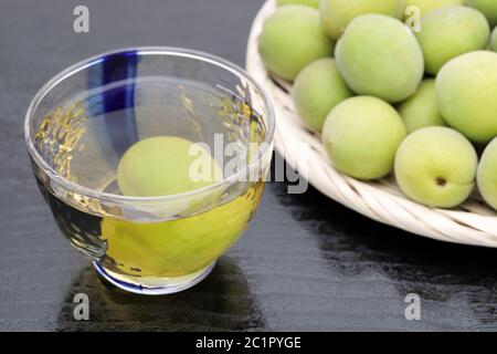 Japanische Pflaume Wein namens umeshu auf schwarzem Hintergrund Stockfoto