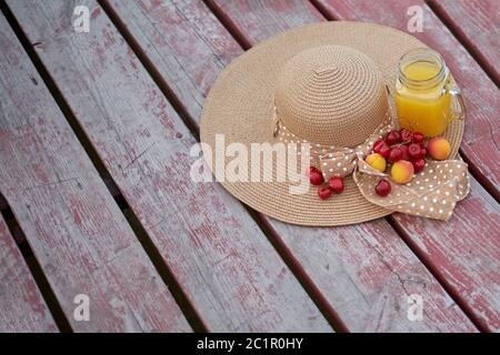 Ein Glas tropischer exotischer Multifruitsaft und Früchte am Pier. Tropisches Picknick am Strand Stockfoto