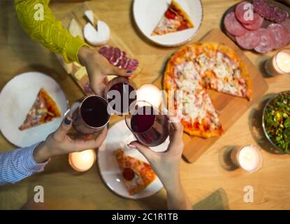 Tabelle mit verschiedenen Lebensmitteln mit Rotwein und Kerzen serviert. Stockfoto