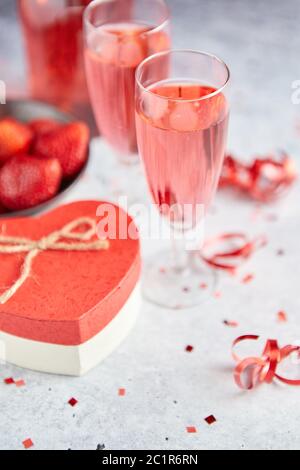 Flasche rose Champagner, Gläser mit frischen Erdbeeren und herzförmige Geschenk Stockfoto