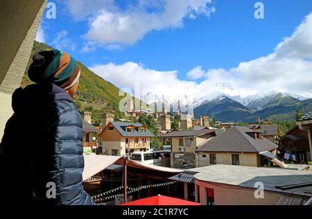 Mann genießen Sie einen atemberaubenden Blick auf Mestia Stadt mit den einzigartigen Svan Tower-Häuser und Kaukasus-Berge, Svaneti Region von Georgien Stockfoto