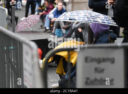 16. Juni 2020, Hessen, Frankfurt/Main: Journalisten und Testbesucher warten vor dem Gerichtsgebäude mit Sonnenschirmen und Campingstühlen auf den Eintritt. Der Prozess gegen den 46-jährigen Stephan E. aus Kassel findet unter Hochsicherheitsmaßnahmen vor dem Senat der Staatssicherheit des Oberlandesgerichts statt. Er soll vor einem Jahr Nordhessens Landrat Walter Lübcke auf seiner Terrasse erschossen haben, weil der CDU-Politiker für Flüchtlinge aufgestanden war. Foto: Arne Dedert/dpa Stockfoto