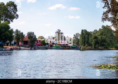 Panoramablick auf Xochimilco Kanäle oder Kanäle entlang der schwimmenden Gärten oder Chinampas in Mexiko-Stadt bei Sonnenuntergang mit ein paar Trajinera Boote in t Stockfoto