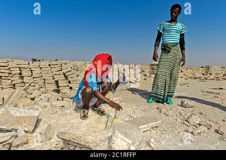 Arbeiter schneiden Blöcke von Salz in einem Salzbruch in Assale Salt Lake, Hamedala, Danakil Depression, Afar Region, Äthiopien Stockfoto