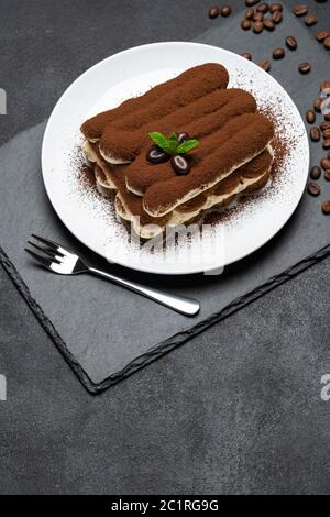 Klassisches Tiramisu Dessert auf Keramikplatte auf Betongrund Stockfoto