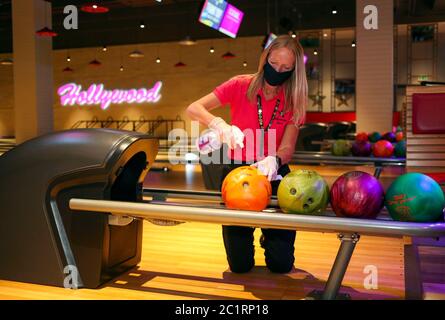 Ein Mitarbeiter des Hollywood Bowl in Thurrock, Essex, reinigt die Bowlingbälle. Eine von mehreren möglichen Maßnahmen zur Arbeitssicherheit, die in Erwartung zukünftiger Leitlinien der britischen Regierung zur Wiedereröffnung von Freizeitunternehmen ergriffen werden. Stockfoto