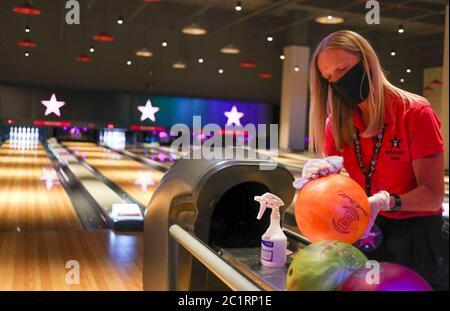 Ein Mitarbeiter des Hollywood Bowl in Thurrock, Essex, reinigt die Bowlingbälle. Eine von mehreren möglichen Maßnahmen zur Arbeitssicherheit, die in Erwartung zukünftiger Leitlinien der britischen Regierung zur Wiedereröffnung von Freizeitunternehmen ergriffen werden. Stockfoto