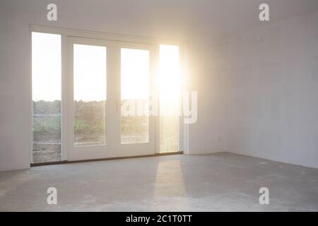 Leeren Raum mit großen Fenstern, Rahmen und Doppel doorsnew Bau, die noch in Bearbeitung mit Sonnenlicht Stockfoto