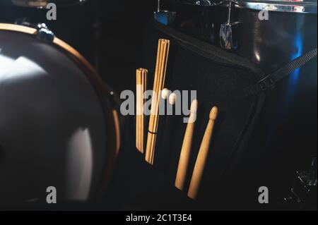 Nahaufnahme von Trommelstöcken in einem Koffer auf einem der Trommeln in einem dunklen Studio. Das Konzept der Live-Performances Stockfoto