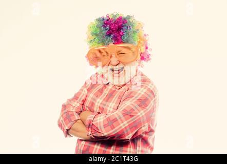 Älterer Clown. Mann Senior bärtige fröhliche Person trägt bunte Perücke und Sonnenbrille. Viel Spaß. Lustiger Lebensstil. Spaß und Unterhaltung. Comic-Großvater-Konzept. Schöner Witz. Opa immer Spaß. Stockfoto