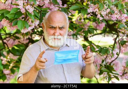 Konzept der Asthmabehandlung. Allergische Reaktion. Begrenzen Sie die Ausbreitung von Infektionen. Gesichtsmaske für ältere Männer. Atemmaske. Pollenallergen. Mensch und Blumen. Atembeschwerden. Atembeschwerden. Stockfoto