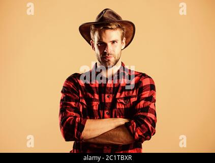 Beispiel wahrer Männlichkeit. Cowboy Hut tragen. American Cowboy. Westliche leben. Mann unrasiert Cowboy beigen Hintergrund. Unrasierten Kerl in Cowboyhut. Schöne bärtige Macho. Schönheit Standard. Stockfoto