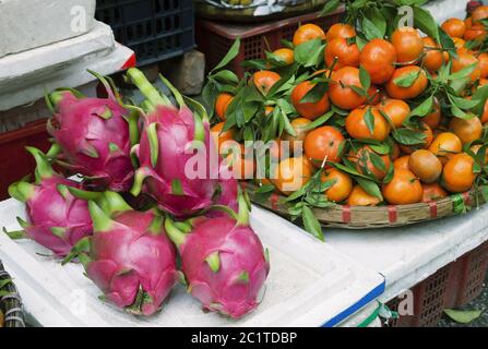 Dragon Früchte und Mandarinen auf einem Markt in Vietnam Stockfoto