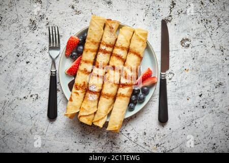 Teller köstliche Crepes Rolle mit frischem Obst und Schokolade Stockfoto