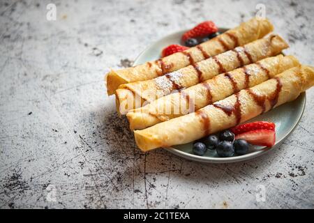 Teller köstliche Crepes Rolle mit frischem Obst und Schokolade Stockfoto