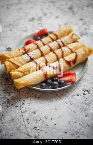 Teller köstliche Crepes Rolle mit frischem Obst und Schokolade Stockfoto