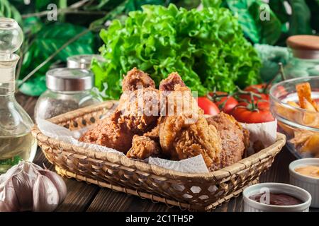 Panierte knusprig gebratene kentucky Hähnchendrumkick im Korb Stockfoto