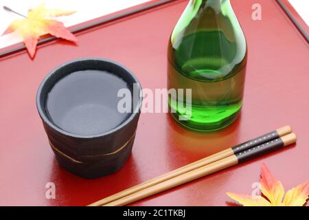 Flasche Japanische shochu und keramische Schüssel auf Holz- fach, auf weißem Hintergrund Stockfoto