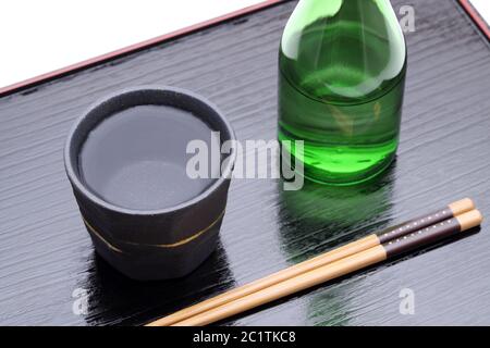 Flasche Japanische shochu und keramische Schüssel auf Holz- fach, auf weißem Hintergrund Stockfoto