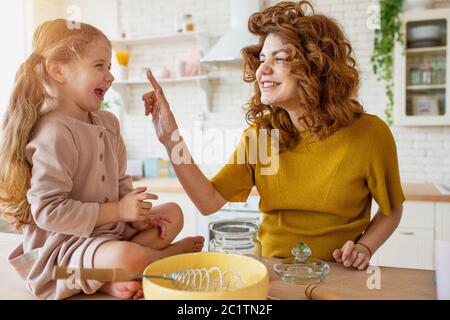 Mutter und Tochter bereiten in der Küche gemeinsam einen Kuchen zu Stockfoto