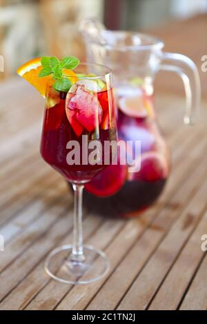 Glas eisgekühlte Sangria mit Erdbeere, Orange, Apfel und Zitrone auf dem Tisch. Stockfoto