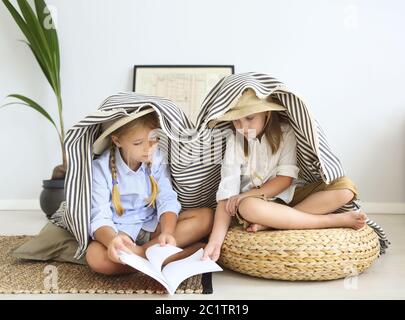 Zwei kleine Mädchen spielen zu Hause auf Reisende tragen Vintage-Stil Kleidung Stockfoto