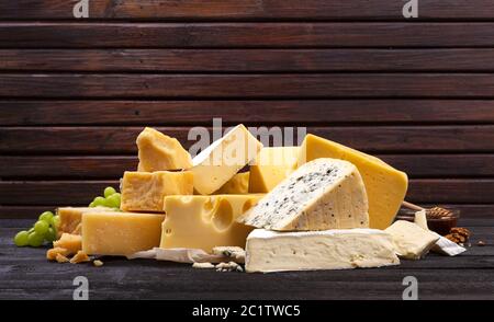 Verschiedene Arten von Käse auf schwarzen Holztisch. Stockfoto