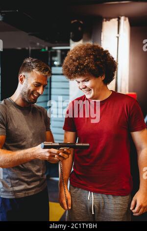 Glücklich übergewichtigen Mann mit Personal Trainer, Ziele zu erreichen, Erfolg Stockfoto