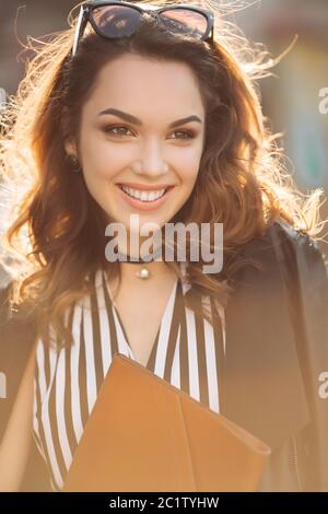 Schöne Brünette Frau in Sonnenbrille lächelt an der Kamera. Stockfoto