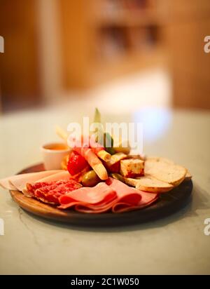 Mischung aus traditionellen spanischen Schinken Salami, parmaschinken auf grissini Brotstäbchen, mariniertes Gemüse und Oliven auf Holzplatte mit Stockfoto