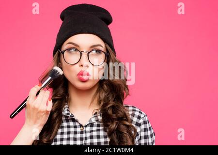 Junge Hipster Mädchen Spaß und verrückt, Tragen Brille Hut hell Make-up. Rosa städtischen Hintergrund. Die Frau machte seine li Stockfoto