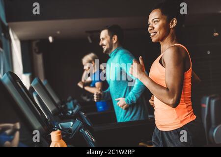 Junge Menschen, die auf einem Laufband im modernen Fitnessraum Stockfoto