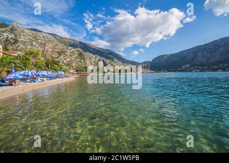 KOTOR, MONTENEGRO - 12. AUGUST 2016: Blick auf den Kotor Strand und einen Teil der Bucht von Kotor während des Tages im Sommer. Menschen können gesehen werden. Stockfoto