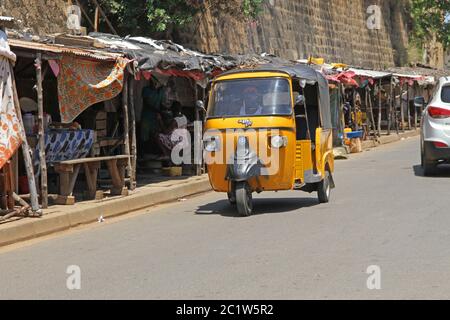Traditionelles Tuk-Tuk-Taxi, das auf der Straße, im Hafen von Andoany oder Hell-Ville, Nosy Be, Madagaskar fährt. Stockfoto