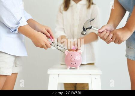 Kinder mit Schraubendreher, Zange und Hammer durch die rosa Schweinebank Stockfoto