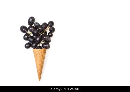 Schwarze Gräber in einem Waffelkegel und auf weißem Hintergrund Stockfoto