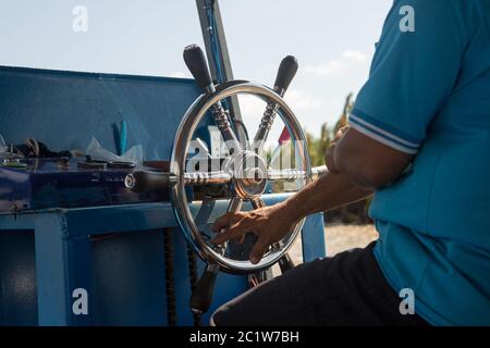 Lenkrad bei einem kleinen Boot das Lenkrad fest halten Stockfoto