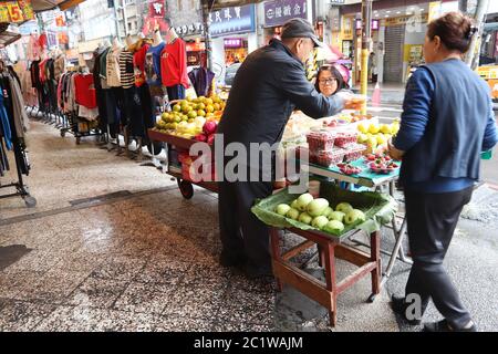 KEELUNG, TAIWAN - 23. NOVEMBER 2018: Straßenhändler verkauft Obst in Keelung, Taiwan. Märkte sind ein wesentlicher Bestandteil der taiwanesischen Esskultur. Stockfoto