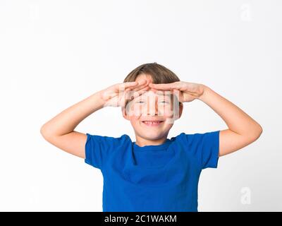 Cool und niedlich sechs Jahre alten Jungen in roten Hosen und blauem Hemd posiert vor weißem Hintergrund Stockfoto