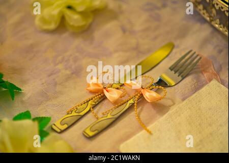 Verzierte Gabel und Messer mit Bändern für Hochzeitsfeier. Stockfoto